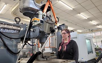 An apprentice working on a machine in the workshop on site at UK ATC.