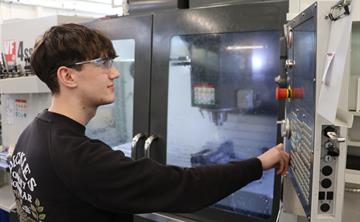 An apprentice working on a machine in the workshop on site at UK ATC.