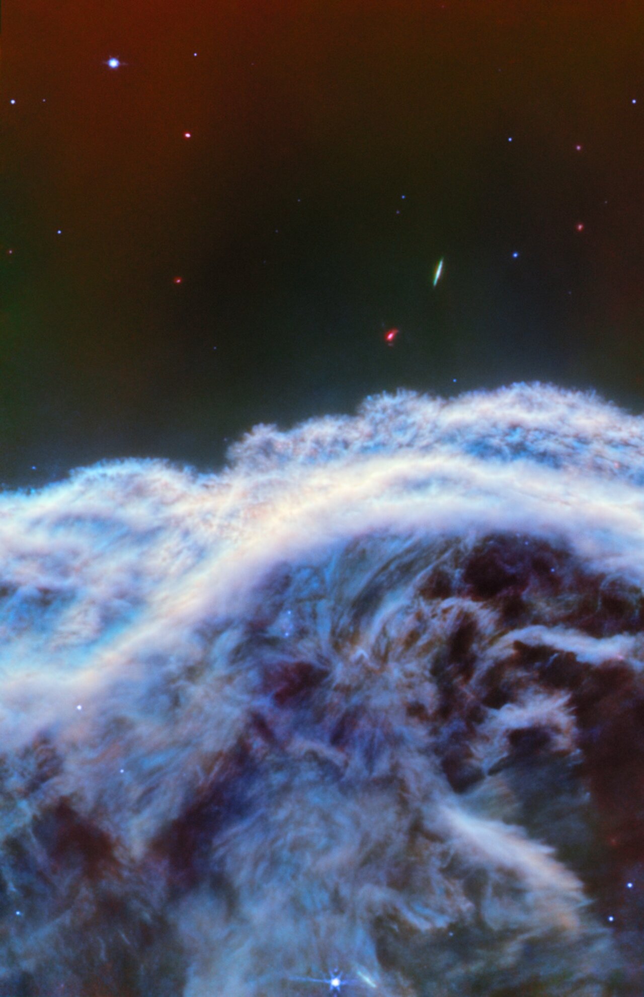 Close up image of the Horsehead Nebula which looks like a cloud of dust surrounded by stars.