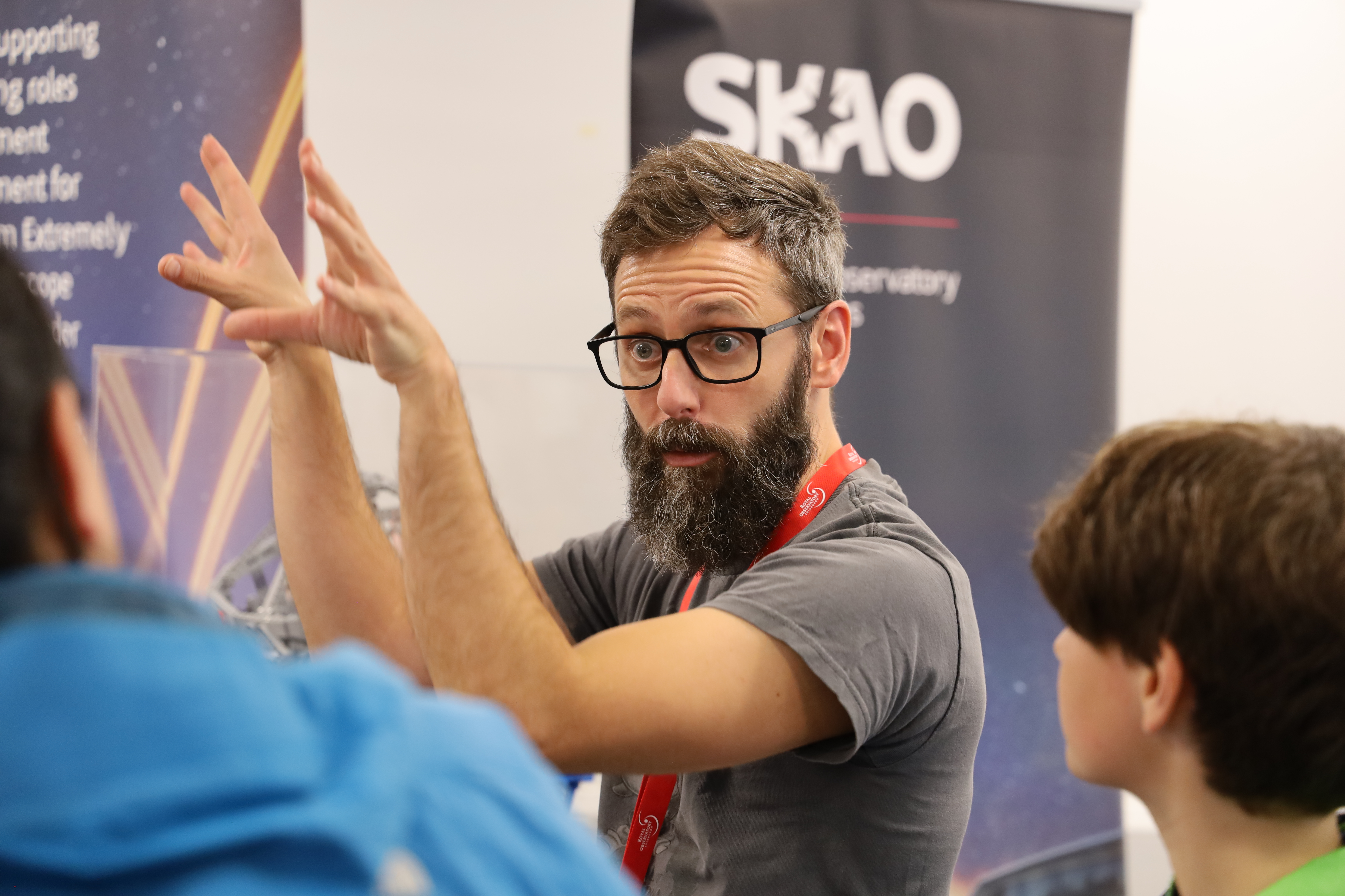 A member of staff talking animatedly about astronomy to the public.